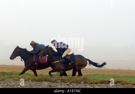Junge Männer üben Rennpferde auf Galoppaden Berkshire, Vereinigtes Königreich Stockfoto