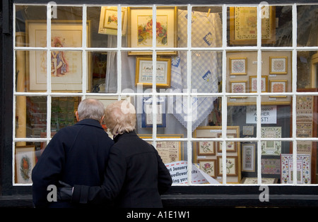 Älteres Ehepaar suchen im Fenster ein Kurzwaren-Shop Burford Oxfordshire UK Stockfoto