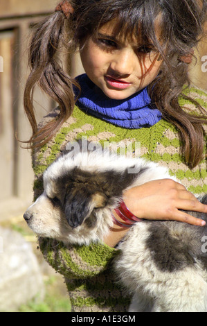 Eine junge einheimische indische Kind Mädchen spielen mit flauschigen weißen Hund niedlichen Welpen, Kalga Dorf, Indien Stockfoto