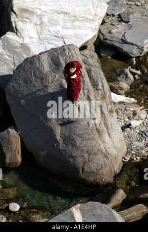 Ein einsamer tibetischen buddhistischen Mann Mönch in traditioneller Kleidung zu Fuß suchen Weg durch Bergschlucht Stockfoto