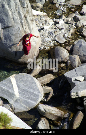 Ein einsamer tibetischen buddhistischen Mann Mönch in traditioneller Kleidung zu Fuß suchen Weg durch Bergschlucht Stockfoto