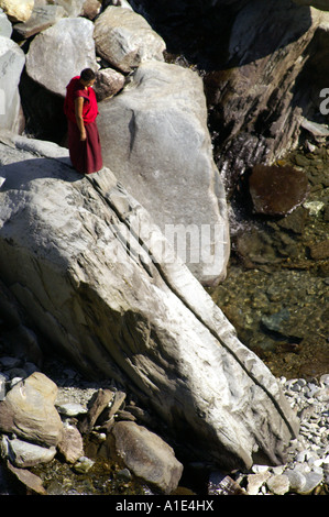 Ein einsamer tibetischen buddhistischen Mann Mönch in traditioneller Kleidung zu Fuß suchen Weg durch Bergschlucht Stockfoto