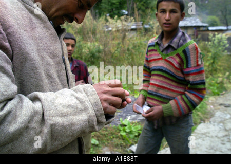 Zuverlässiger Führer Mann Buyig Haschisch von jungen Teenager Händler im Dorf Malana, Indien Stockfoto