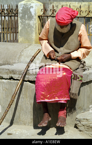 Alten indischen Heiligen Sadhu Yogi Pilger Mann sitzt Rollig eine Zigarette in Manikaran, Parvati-Tal, Indien Stockfoto