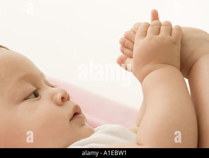 Baby spielt mit Fuß Stockfoto