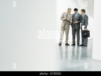 Drei Unternehmer stehen in der Lobby, Blick in die Datei Stockfoto