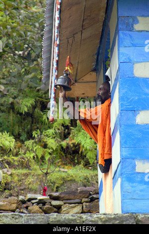 Alte indische Yogi Sadhu heiliger Mann rituelle läuten im Shiva-Tempel in Khirganga Hot Springs in Parvati-Tal Stockfoto