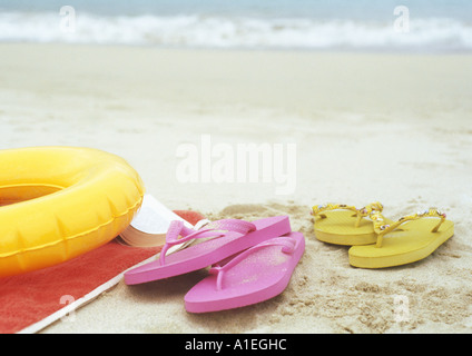 Flip-Flops und Innertube am Strand Stockfoto