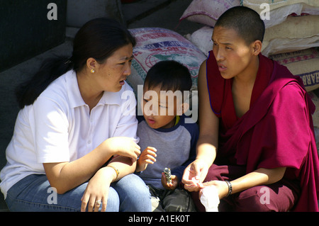 Tibetische Familie - lässig gekleidet Frau, buddhistischer Mönch Mann und der junge Kind sitzt im freien Stockfoto