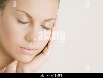 Junge Frau mit Augen geschlossen ruhenden Kopf auf Seite Stockfoto