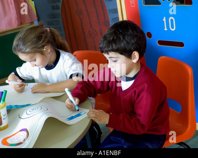 Jungen und Mädchen im Kindergarten Klassenzimmer mit Malbücher und Buntstifte mit der Nummer 10 auf Spielzimmer Tür hinter Stockfoto