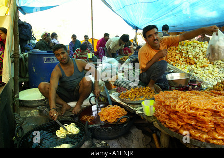 Mann Braten Süßigkeiten an Dussehra fair mit enormen Vielfalt an reiche indische Küche Mahlzeiten, Kullu, Indien Stockfoto