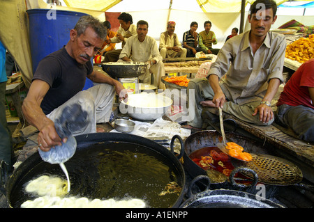 Mann Braten Süßigkeiten an Dussehra fair mit enormen Vielfalt an reiche indische Küche Mahlzeiten, Kullu, Indien Stockfoto