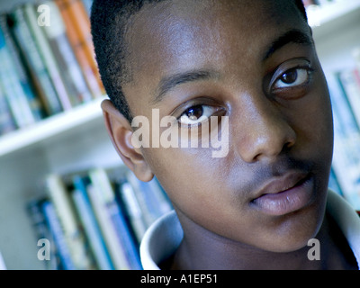 Schule Teenager schließen Gesicht mit Bücher hinter der Schwarzen in Afrika, im Karibischen Raum student nachdenkliche Porträt in der Schule Bibliothek in der Studie Situation Stockfoto
