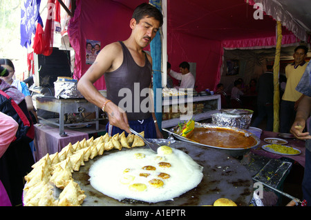 Mann Pfanne Kuchen bei Dussehra fair mit enormen Vielfalt an reiche indische Küche Mahlzeiten, Kullu, Indien Stockfoto