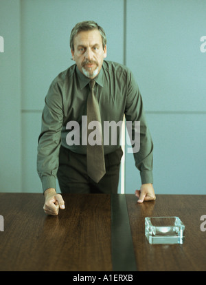 Geschäftsmann hämmerte Faust auf den Tisch, Porträt Stockfoto