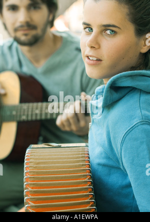 Junge Frau spielt Akkordeon und junge Mann spielt Gitarre Stockfoto