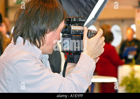 Mann mit modernen digitalen Mittelformat-Kamera bei Demonstration in Fachausstellung im NEC Stockfoto