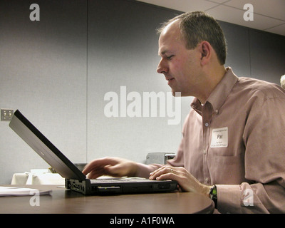 Geschäftsmann arbeitet an seinem Laptop an einem Tisch Stockfoto