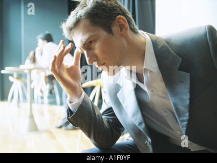 Geschäftsmann hält Kopf, seitliche Ansicht Stockfoto