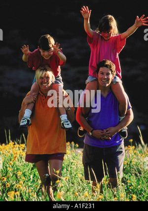 Familie gehen und spielen im freien Kinder sind auf Eltern Schultern Reiten. Stockfoto