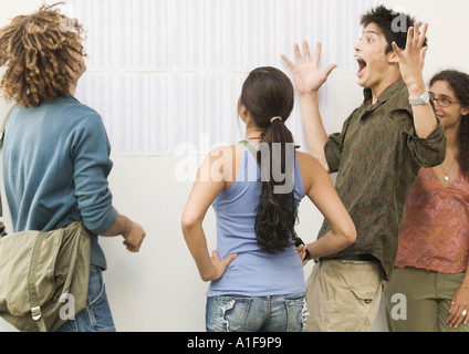 Studenten auf Pinnwand veröffentlicht Ergebnisse zu betrachten, schreien eine vor Freude Stockfoto