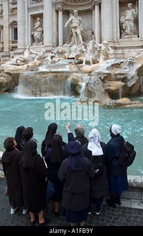 Eine Gruppe katholischer Nonnen besucht den Brunnen Fontana di Trevi im Barockstil in Rom, Italien Stockfoto