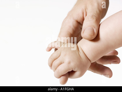 Hand des Mannes an Hand des Babys Stockfoto