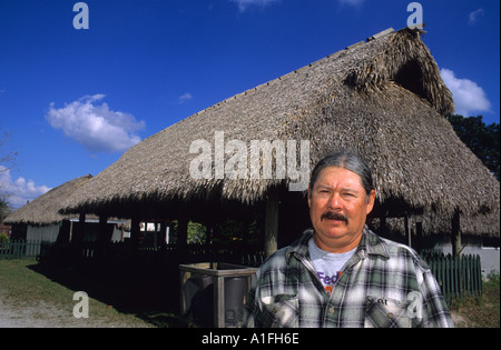 Ted Billie seminole Miccosukee Indian stehend vor einem Chopekcheke traditionellen Reetdach in Florida wohnen Stockfoto