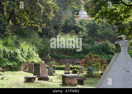 Grabsteine in britischen Garnison Friedhof mit Dagoba im Hintergrund. Kandy, Sri Lanka Stockfoto