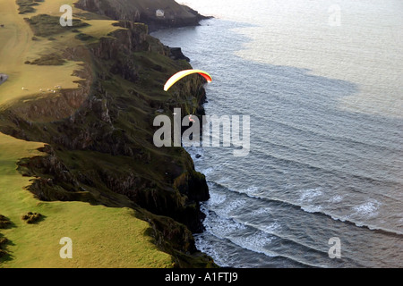 Luft-Luft-Schuss von Gleitschirm fliegen über dem Meer über Klippen von Rhossili Bucht Gower Halbinsel Wales UK Stockfoto