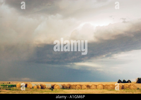 Gewitterwolken über Kansas Feld mit Heuballen USA Stockfoto