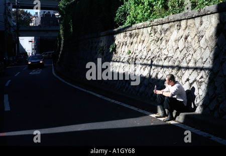 Ein Bauarbeiter nimmt eine Pause am Vormittag in Tokio Stockfoto