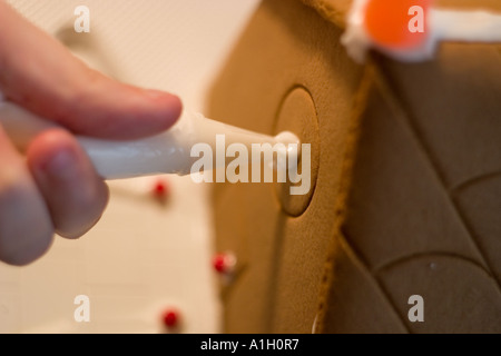 Lebkuchenhaus machen Hand mit Zuckerguss Rohr Stockfoto