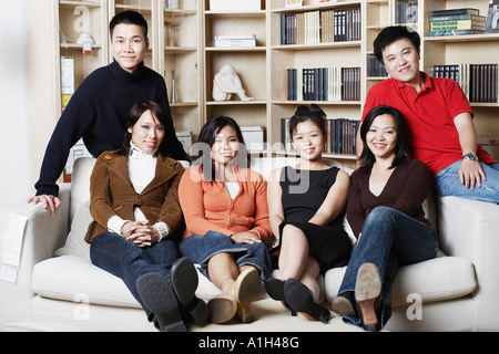 Porträt von vier jungen Frauen und zwei junge Männer sitzen auf einer couch Stockfoto