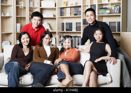 Porträt von vier jungen Frauen und zwei junge Männer sitzen auf einer couch Stockfoto