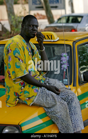 Fahrer sitzt auf Motorhaube von Taxi The Cape in Bakau Gambia Stockfoto