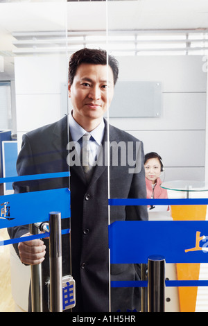 Porträt eines Geschäftsmannes stehend in einem Büro mit einer reifen Frau einen Kopfhörer tragen Stockfoto