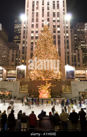 Weihnachtsbaum und Skater im Rockefeller Center, New York City. Das RCA-Gebäude befindet sich hinter dem Baum. Stockfoto