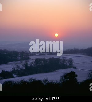 Die untergehende Sonne über den Schnee bedeckt Felder in der Nähe von Newlands in Surrey Stockfoto