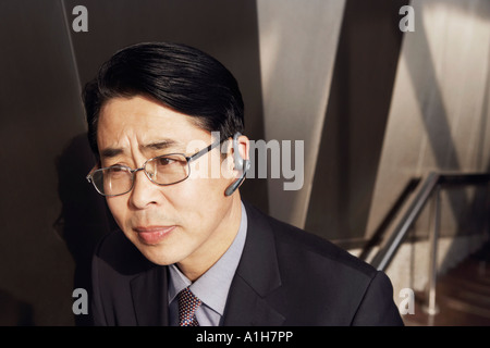 Erhöhte Ansicht eines Geschäftsmannes tragen eine Hände frei Gerät Stockfoto