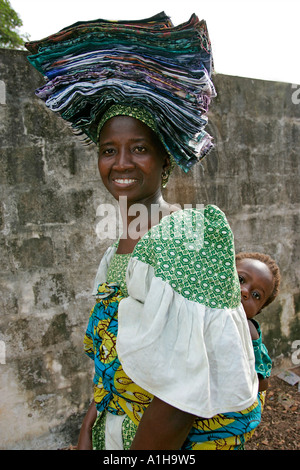 Fula Frau trägt gefaltetes Tuch auf dem Kopf und Baby auf Rückseite Bakau Gambia Stockfoto