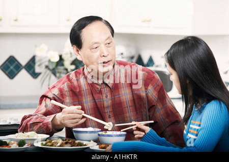 Großvater und seine Enkelin an einem Tisch sitzen Stockfoto