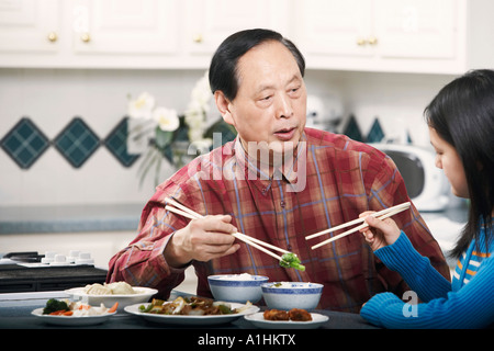 Großvater und seine Enkelin an einem Tisch sitzen Stockfoto