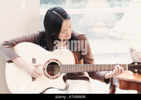 Nahaufnahme eines Mädchens, die Gitarre zu spielen Stockfoto