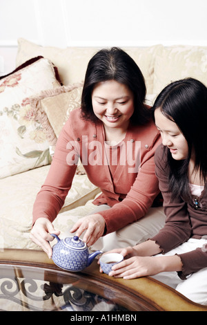 Erhöhte Ansicht einer Mutter Gießen Tee für die Tochter Stockfoto
