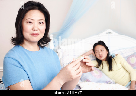 Porträt einer Mutter ihre Tochter Temperatur prüfen Stockfoto