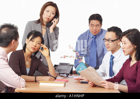 Drei Unternehmer und drei Unternehmerinnen in einer Besprechung Stockfoto