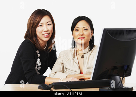 Porträt von zwei Geschäftsfrauen sitzen vor einem computer Stockfoto