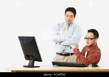 Zwei Geschäftsleute, die ein LCD-Monitor betrachten Stockfoto